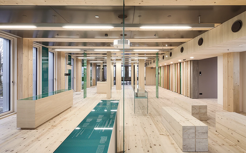 Holz- und Systembau LifeCycle Tower Rhomberg Bau Innenraum aus Holz mit Bänken Holz- und Systembau LifeCycle Tower Rhomberg Bau Innenraum aus Holz mit Bänken